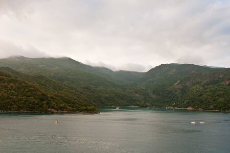 A green hilly island under foggy morning lightの写真素材