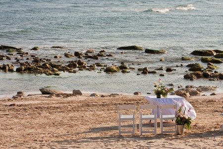 A table on a beach set with flowers for a weddingの写真素材