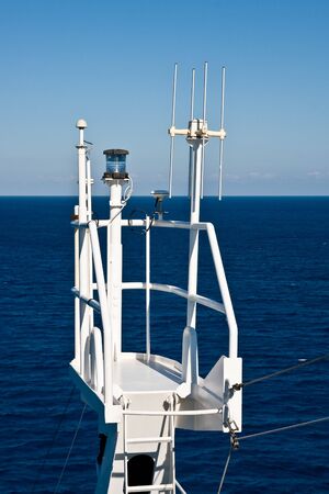 A white observation platform on the side of a ship with beacon and antennasの写真素材
