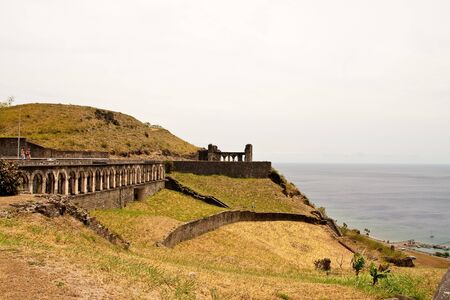 Old stone walls from  ancient fortifications on a green hilltopの写真素材