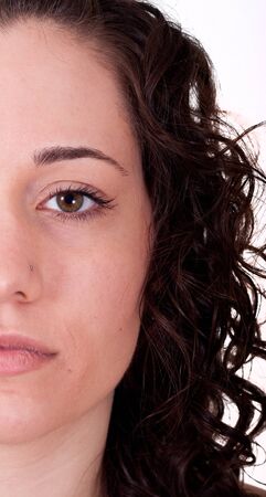 A young brunette woman looking at camera half faceの写真素材