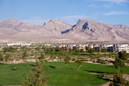 Carts on a Desert Golf course by condos and mountainsの写真素材