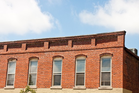 An old brick building with wooden sash windows under nice skyの写真素材