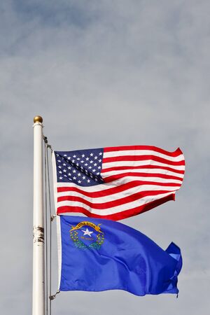 An American and Nevadan flag on a white flagpoleの写真素材