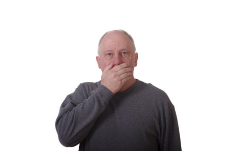 An older man with hand over mouth