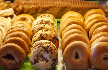 A variety of fresh hot bagels in a baker's case