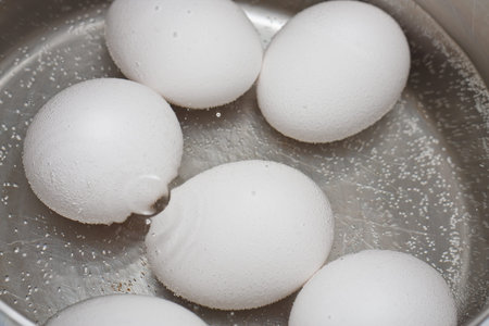 Fresh eggs simmering in a pot of water