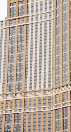 A massive modern high rise hotel of brown stone and blue glassの写真素材