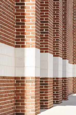 A row of red brick columns with white blocks into the distanceの写真素材