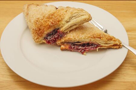 Two raspberry turnovers on a white plateの写真素材