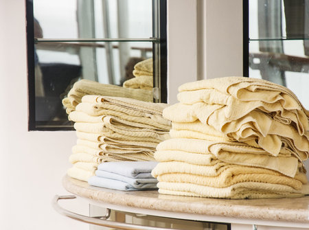 Yellow towels piled on a counter near swimming poolの写真素材