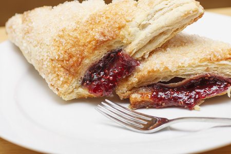 Two raspberry turnovers on a white plateの写真素材