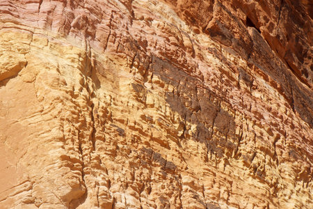 Bands of colors on a red rock wall