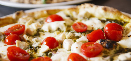 Fresh hot pizza with cheese and cherry tomatoes
