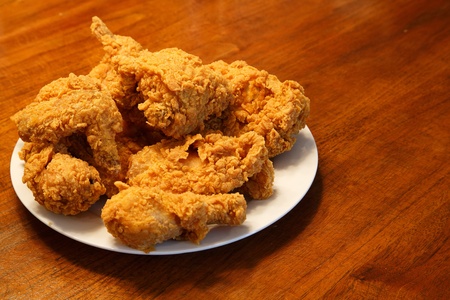 Fresh fried chicken on a white plate set on a wood tableの写真素材