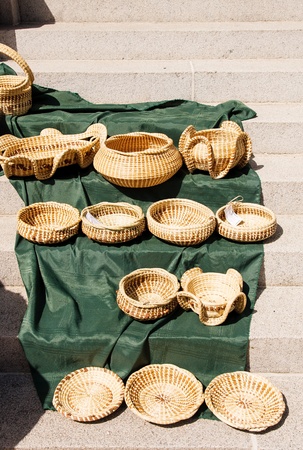 Hand woven baskets in a market on green blanket on stepsの写真素材
