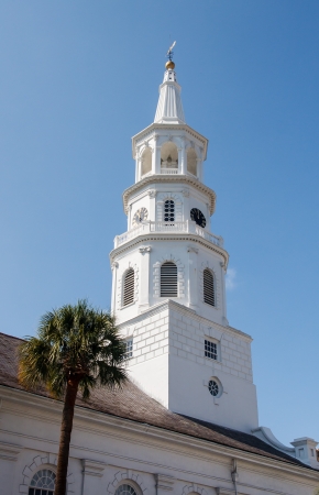 A white church steeple with clock rising into a clear blue skyの写真素材
