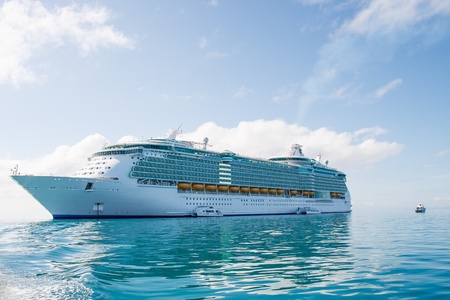 A huge luxury cruise ship anchored under nice skies on calm green waterの写真素材