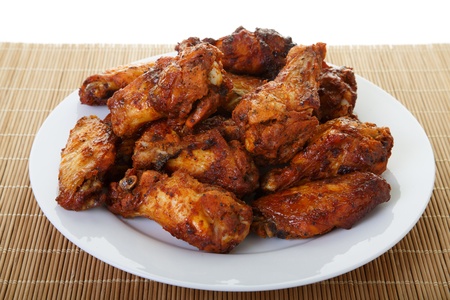 A white plate of spicy, mesquite flavored chicken wingsの写真素材