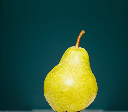 A green Bartlett pear on a green background