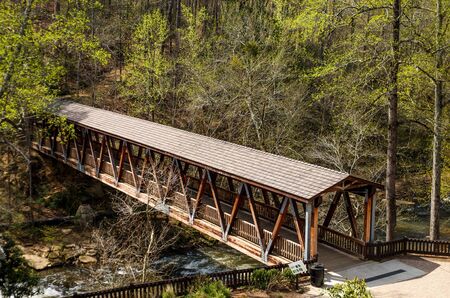 An old wooden, covered bridge in springtime forestの写真素材