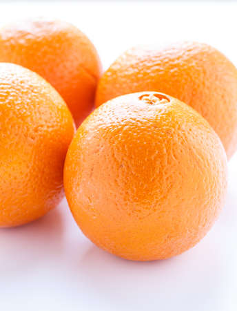 Four fresh naval oranges in window lightの写真素材