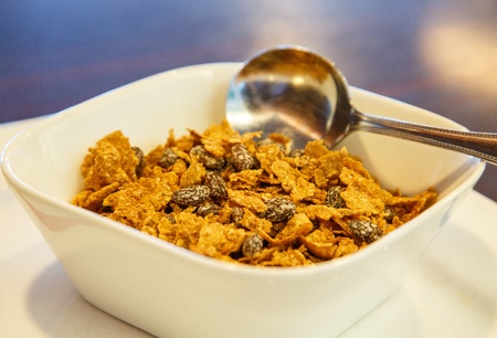 A bowl of raisin bran with spoonの写真素材
