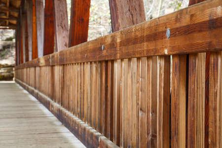 An old wooden, covered bridge in springtime forestの写真素材