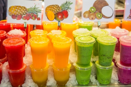 A variety of colorful, fruity drinks on ice in a Barcelona, Spain marketの写真素材