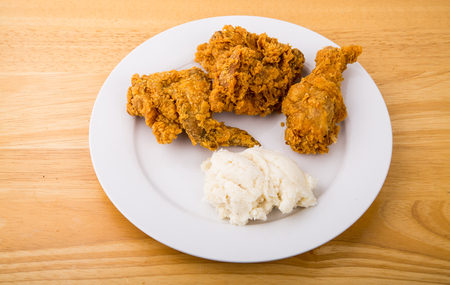 A plate of crispy fried chicken with a side of mashed potatoesの写真素材