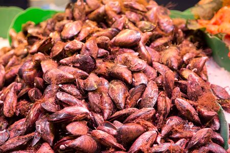 Bin full of fresh mussels in a seafood marketの写真素材