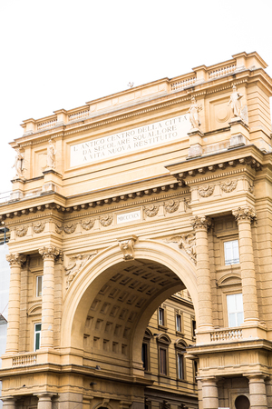 An ancient arch at the edge of a town square in Florence, Italyの写真素材