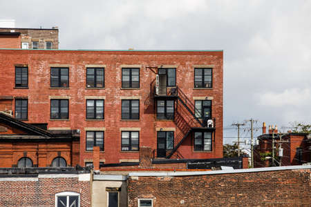 Black iron fire escapes on old brick buildings in Canadaの写真素材