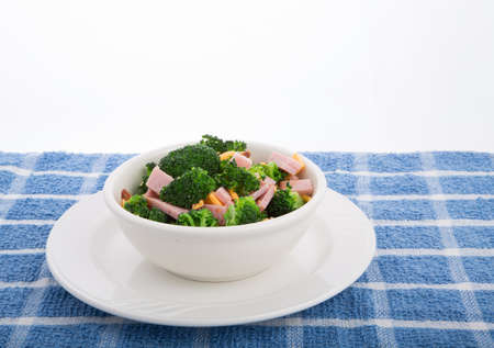 A fresh salad of green broccoli, sliced ham and grated cheddar cheeseの写真素材