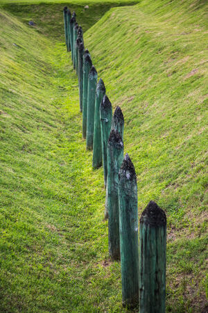 Sharpened wood stakes in ditch around an old fortificationの写真素材