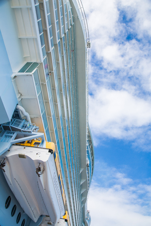 Decks of a cruise ship with lifeboat beneath beautiful skiesの写真素材