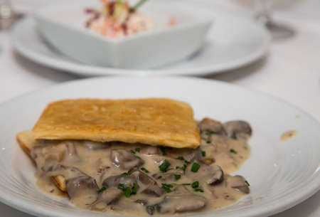 A delicious mushroom appetizer in puff pastry on white plateの写真素材