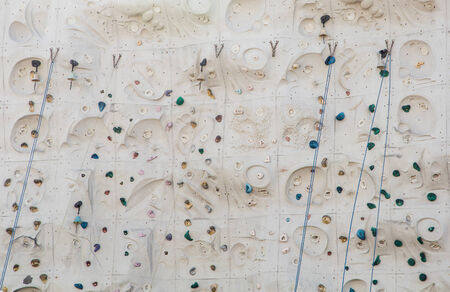 Ropes, bells and ropes on a large rock climbing wallの写真素材