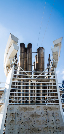 A rock climbing wall under smokestacks on a modern, luxury cruise shipの写真素材