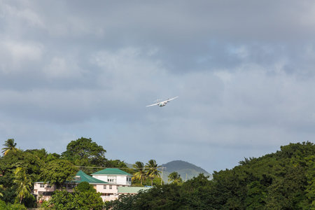 A twin propeller plane taking off over a tropical paradise
