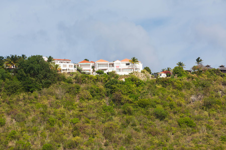 A large mansion on top of a green tropical hillの写真素材