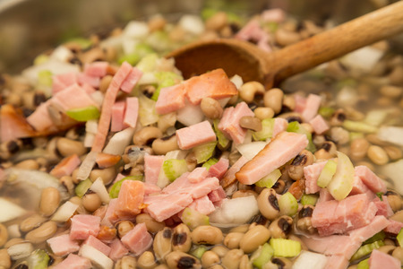 Cooking a pot of black-eyed peas with ham, onion and celeryの写真素材