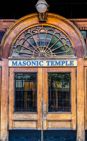 An old wooden door with iron bars on a Masonic Temple in St Johns, Canadaの写真素材