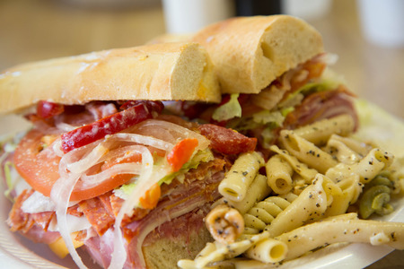 An italian sub sandwich on french roll with fresh pasta saladの写真素材