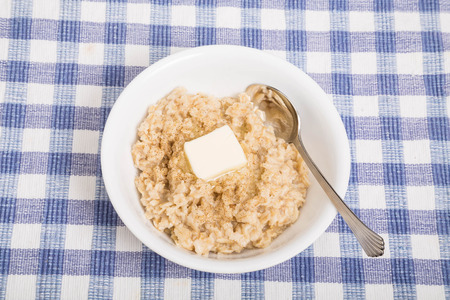A bowl of hot, fresh cooked oatmeal with melting butterの写真素材