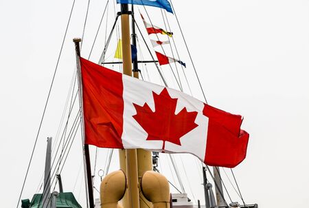 Maple Leaf on Huge Canadian Flag flying on an old shipの写真素材