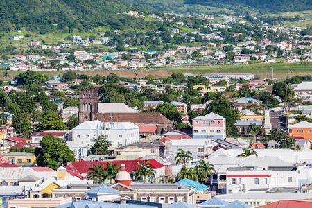 An old stone church amond Colorful buildings in St Kitts twon in the Caribbeanの写真素材