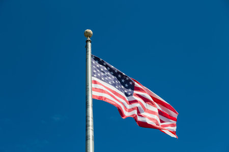 American Flag blowing in the wind at the top of a flagpole