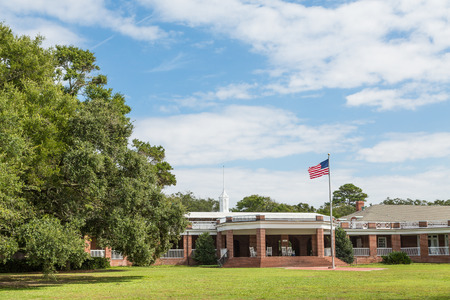 A public brick pavilion in a park with American flag out frontのeditorial素材