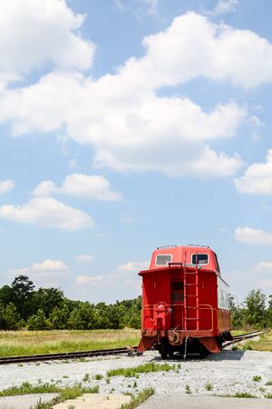 An old red caboose on a track under blue skiesの写真素材